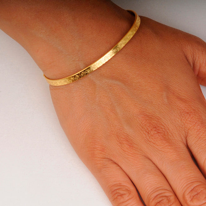 Brazalete delgado espirales dorado